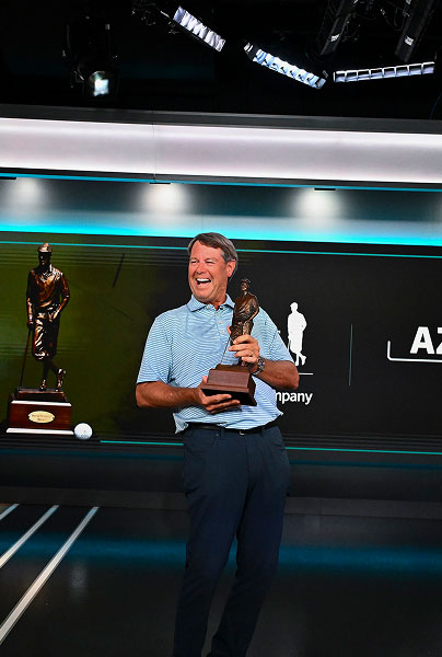 Paul Azinger laughing and holding Payne Stewart Award trophy